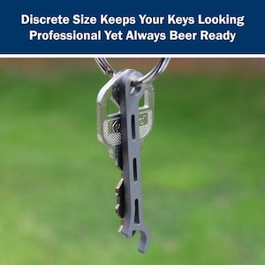 May include: A silver key chain with a bottle opener attached. The bottle opener is attached to a key ring. The key chain is hanging from a key.
