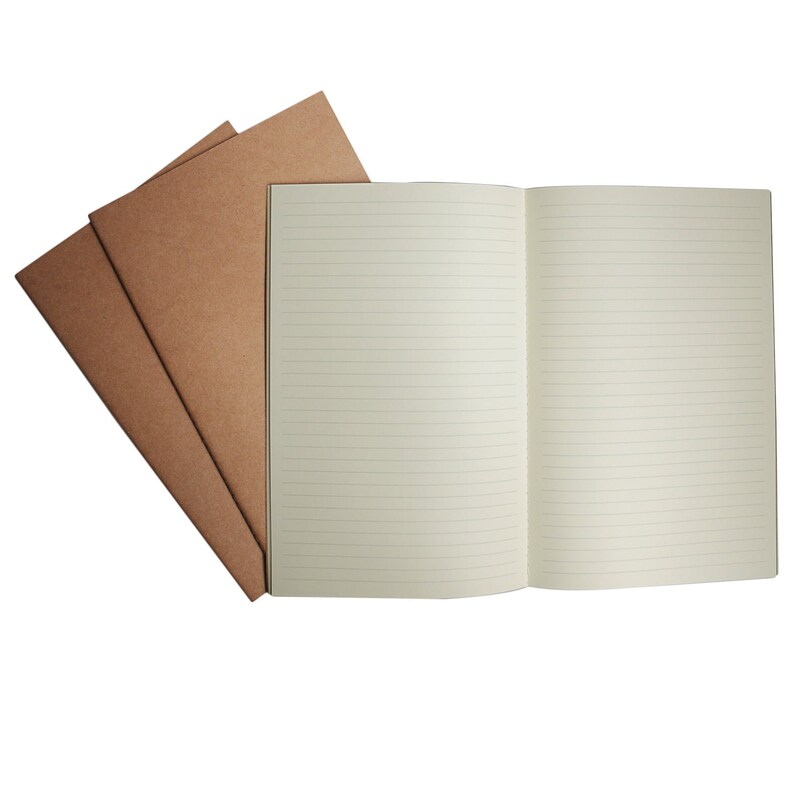 May include: An open notebook with lined pages and a brown paper cover. The notebook is lying on a white surface.