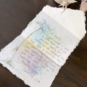 Puede incluir: Una nota de agradecimiento escrita a mano en papel texturizado con una ilustraci&oacute;n de flor de acuarela. La nota dice "Hi Jennifer, I just wanted to send a little thank you to you and your family for hosting us last weekend! We had such a wonderful time at your cottage, and appreciated your generosity and such delicious food!! Hopefully you all will visit us sometime soon! Thanks again, Janet & Jim."