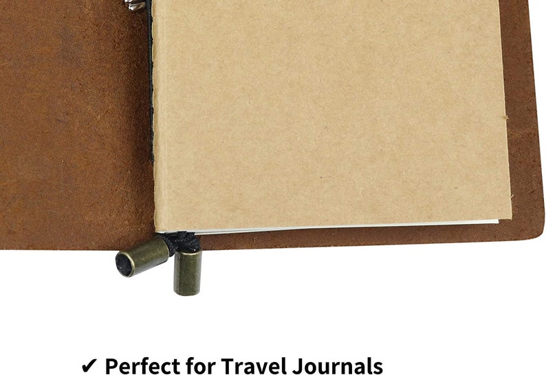 May include: A brown leather bound journal with a blank, cream-colored paper insert. The journal has a black string closure with two metal toggles.