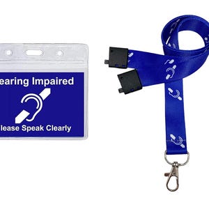 Puede incluir: Lanyard azul con un s&iacute;mbolo blanco de discapacidad auditiva y un portagafete de pl&aacute;stico transparente con el texto "Hearing Impaired" y "Please Speak Clearly".