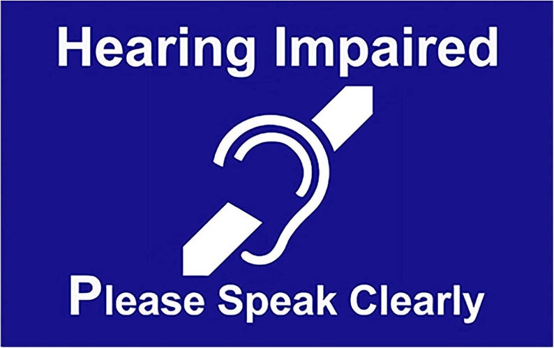 Puede incluir: Un cartel azul con texto blanco que dice "Hearing Impaired" y un s&iacute;mbolo blanco de una oreja estilizada con una l&iacute;nea diagonal que la atraviesa. El cartel tambi&eacute;n tiene el texto "Please Speak Clearly" en blanco.