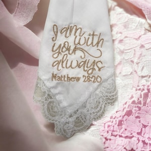 May include: White handkerchief with lace trim and gold embroidery that reads "I am with you always Matthew 28:20".
