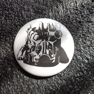 May include: A white button with a black and white silhouette of a person wearing a helmet and gas mask.