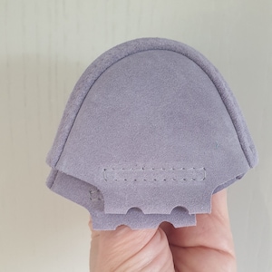 May include: A pair of purple suede shoe inserts with a stitched seam across the top.