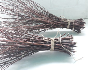 May include: Two bundles of brown twigs tied together with twine. The twigs are arranged in a fan shape.