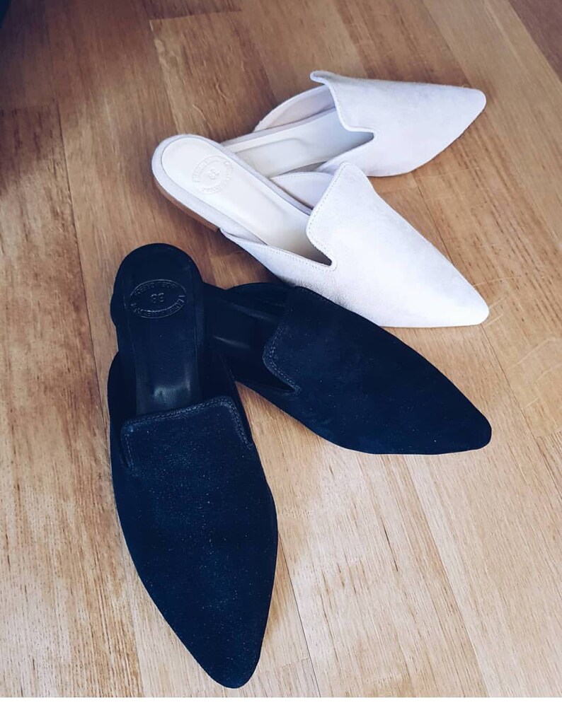 Puede incluir: Dos pares de zapatos de vestir de punta estrecha. Un par es de ante negro y el otro par es de ante blanco roto.