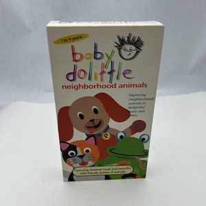 May include: A Baby Dolittle VHS tape featuring cartoon animals. The cover shows a dog, cat, and frog. The text reads "neighborhood animals" and "Exploring neighborhood animals in delightful music and video."