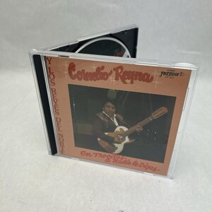 Op de afbeelding: Een cd-hoesje met het album "En Trocitos... a Nadie le Digas" van Cornelio Reyna. De albumhoes heeft een sepia-tint met een foto van een man die gitaar speelt. De tekst "Y Los Reyes Del Norte" staat aan de linkerkant.