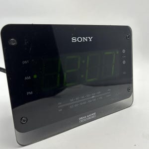 Puede incluir: Reloj despertador digital Sony Dream Machine negro con una pantalla LED verde que muestra la hora. El reloj tiene capacidades de radio FM y AM y presenta un diseño elegante y moderno. El reloj también tiene una configuración DST (horario de verano).