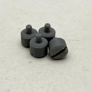 May include: Four grey plastic tripod mounts with threaded holes.