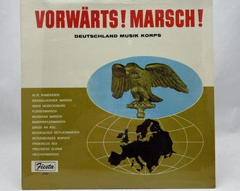 May include: A vintage vinyl record cover featuring a golden eagle with outstretched wings against a blue and white background. The cover is titled "Vorwärts! Marsch!" and features the text "Deutschland Musik Korps". The cover lists a variety of marches, including "Alte Kameraden", "Grossglockner Marsch", and "Hoch Heidesburg".