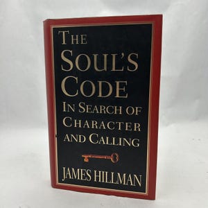 May include: A red hardback book with a black spine and gold lettering. The title is "The Soul's Code: In Search of Character and Calling" by James Hillman.