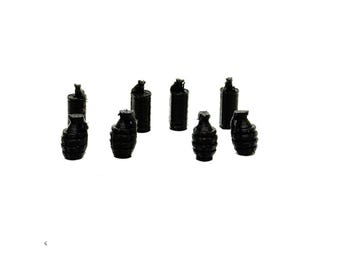 May include: A collection of small, black, toy grenades and spray paint cans are arranged against a white background. The grenades have a textured surface, and the spray paint cans have a cylindrical shape.