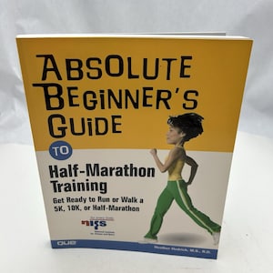 May include: A book titled "Absolute Beginner's Guide to Half-Marathon Training." The cover features a yellow and white background with black text and an illustration of a person running. The book is designed to help people prepare for a 5K, 10K, or half-marathon.