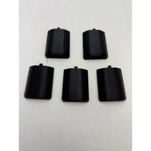 Könnte beinhalten: Fünf schwarze rechteckige Objekte aus Kunststoff mit leicht abgerundeter Ober- und Unterseite. Die Objekte haben eine strukturierte Oberfläche.
