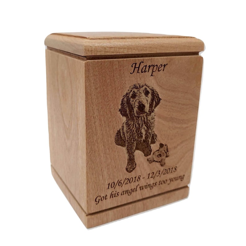 May include: A wooden pet urn with a laser engraved image of a dog and the text "Harper 10/6/2018-12/3/2018 Got his angel wings too young".