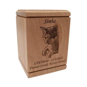 May include: A wooden pet urn with a laser engraved image of a cat and the text "Simba 1/28/20010-12/3/2020 Forever Loved, Forever Missed".
