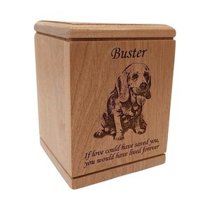May include: A wooden pet urn with an engraved image of a dog and the name "Buster". The urn has the inscription "If love could have saved you, you would have lived forever".