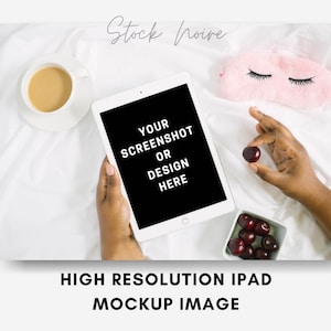 May include: A white iPad mockup with a black screen displaying the text "YOUR SCREENSHOT OR DESIGN HERE". The iPad is on a white bedspread with a pink eye mask, a cup of coffee, and a bowl of cherries.