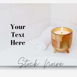 May include: A wooden candle holder with a gold rim and three legs, holding a lit candle. A white towel is on the surface next to the candle holder. The background is a white tiled wall. "Your Text Here" is written in black text on the left side of the image. "Stock Noire" is written in gray cursive text at the bottom of the image.