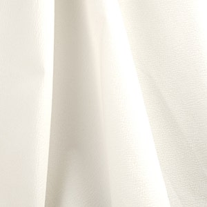 May include: White fabric with a textured surface. The fabric is folded and draped, creating soft folds and shadows.