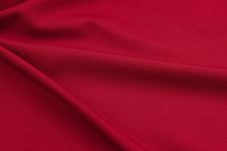 Dettaglio tessuto Punto Milano rosso ciliegia, elasticizzato e fluido, ideale per gonne moderne e pantaloni comodi