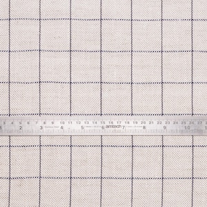 May include: A close-up of a white fabric with a subtle herringbone pattern and a thin black grid. A ruler is placed on the fabric, showing measurements in inches.