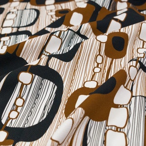 Peut inclure: Tissu abstrait avec un motif géométrique brun, noir et blanc. Le tissu a une surface texturée et un motif répétitif.