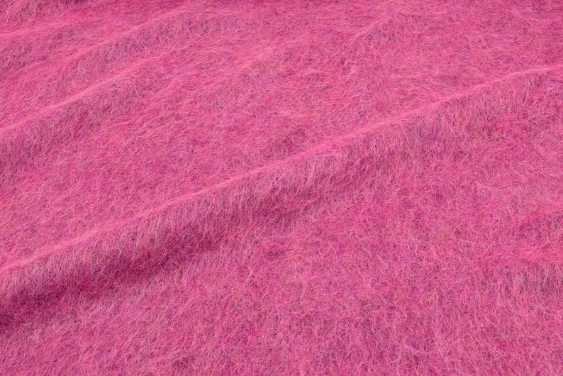 Italienischer Stoff in kräftigem Pink mit flauschiger, voluminöser Oberfläche.