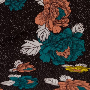 May include: Black fabric with a repeating pattern of teal and peach flowers with white leaves. The background is a dark black with a subtle white speckled pattern.