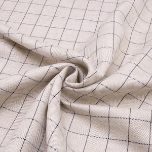 May include: Beige fabric with a black and white checkered pattern. The fabric is woven with a herringbone texture.