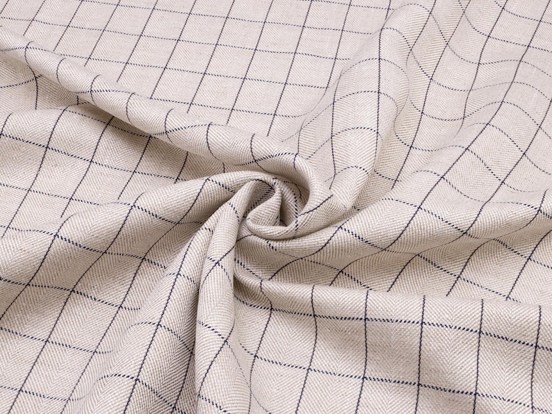 May include: Beige fabric with a black and white checkered pattern. The fabric is woven with a herringbone texture.