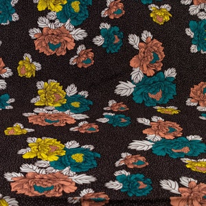May include: Black fabric with a repeating pattern of pink, yellow, and teal flowers. The flowers have white outlines and are on a black background with white dots.