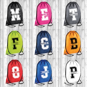 May include: Nine drawstring bags in various colours with a large letter on the front. Each bag has a name printed below the letter. The names are: Maeve, Elsa, Timothy, Fiona, Charlie, Brad, Olivia, Jordan, and Poppy.
