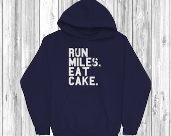 May include: A navy blue hooded sweatshirt with the text "RUN MILES. EAT CAKE." printed in white on the front.