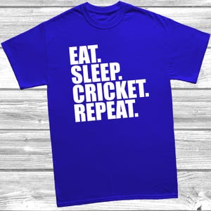 May include: A royal blue t-shirt with the text "EAT. SLEEP. CRICKET. REPEAT." in white.
