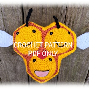 May include: A handmade crochet bee pattern in yellow, orange, and white. The bee has black eyes, antennae, and a smiling face with a pink tongue. The text "CROCHET PATTERN PDF ONLY" is displayed on the bee.