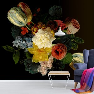 May include: A dark background with a large bouquet of colorful flowers, including tulips, roses, and daffodils. The flowers are arranged in a vase and are illuminated by a hanging light fixture.