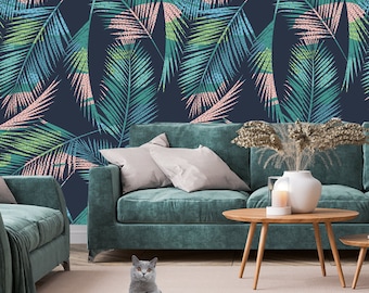 May include: A teal green sofa with a throw blanket and pillows sits in front of a wall with a tropical leaf pattern. The leaves are in shades of green, blue, and pink on a dark blue background.