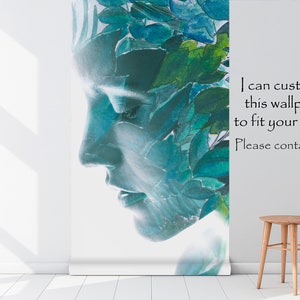 May include: A wallpaper roll featuring a serene face profile, overlaid with watercolor leaves in shades of blue and green. The text on the wallpaper reads, "I can customize this wallpaper to fit your needs. Please contact me :)". A small wooden stool sits nearby.