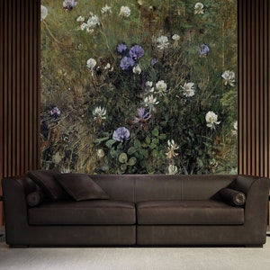 May include: A dark brown leather sofa with two pillows in front of a wall with a floral print. The print features white and purple flowers on a green background.