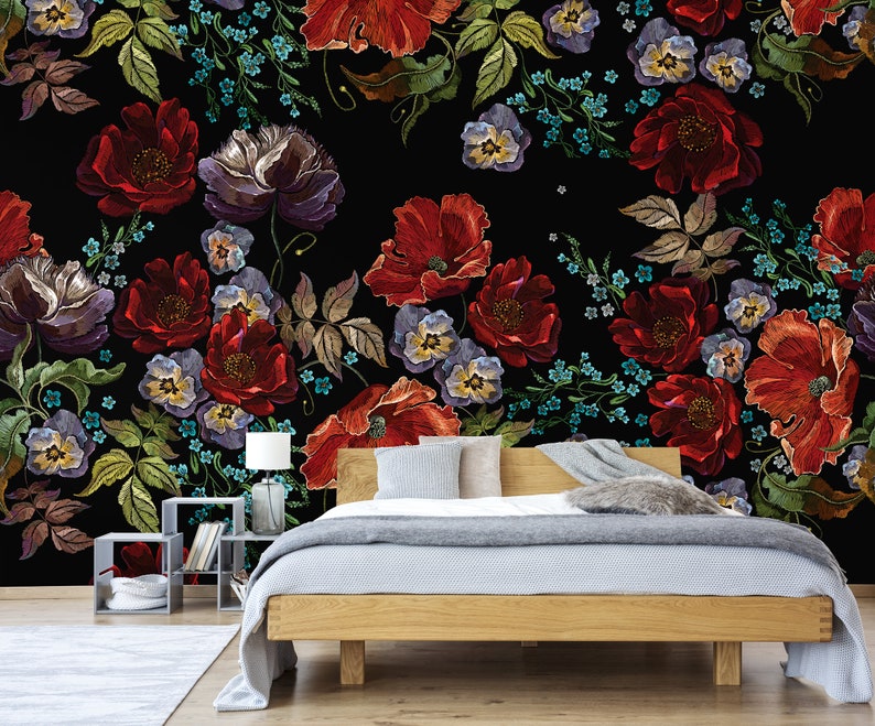 May include: A black background with a floral pattern of red, purple, and blue embroidered flowers. The flowers are arranged in a diagonal pattern and are surrounded by green leaves.