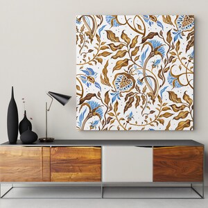 Puede incluir: Una consola multimedia de madera con un cajón blanco y dos puertas de madera marrón. Una lámpara negra con una pantalla blanca se encuentra sobre la consola, junto con tres jarrones negros. Una impresión enmarcada con un patrón floral azul y marrón cuelga en la pared sobre la consola.