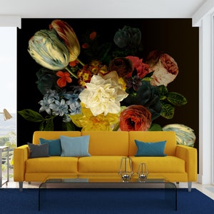 May include: A yellow couch with blue pillows in front of a wall mural featuring a large bouquet of colorful flowers, including tulips, roses, and lilies, on a black background.