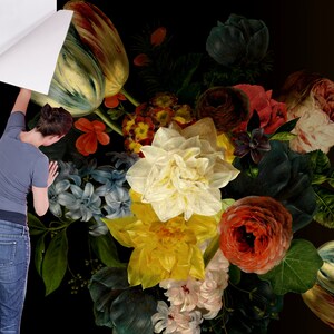 May include: A close-up of a floral arrangement featuring a variety of flowers, including tulips, roses, and lilies. The flowers are arranged in a vase and are set against a dark background.