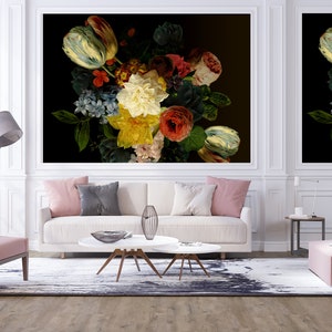 May include: A white sofa with pink and gray throw pillows sits in front of two large framed prints of a still life of colorful flowers on a black background.