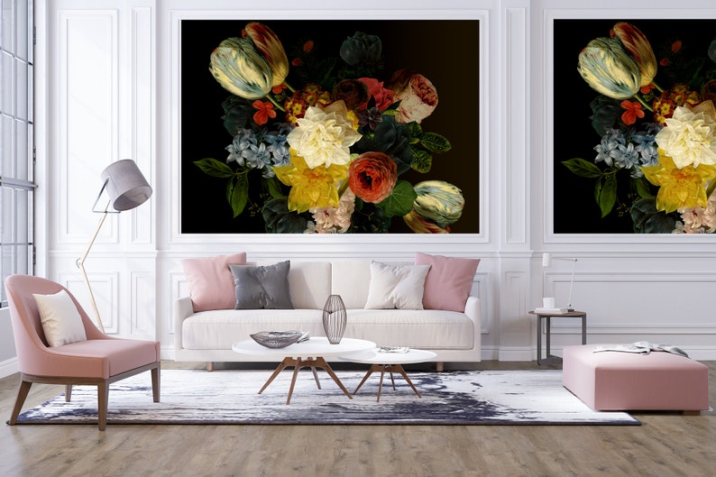 May include: A white sofa with pink and gray throw pillows sits in front of two large framed prints of a still life of colorful flowers on a black background.
