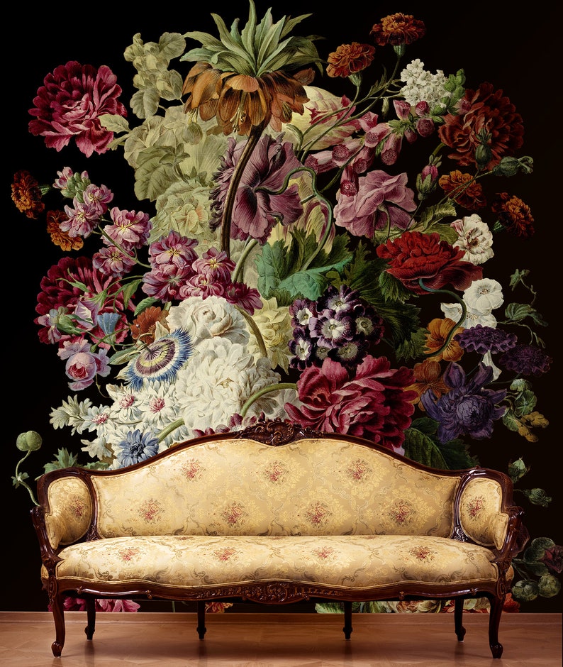 May include: A vintage-style floral wallpaper featuring a large bouquet of colorful flowers, including roses, lilies, and carnations, arranged in a vase. A beige fabric sofa with ornate wooden legs sits in front of the wallpaper.