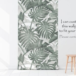 May include: A white wall with a green and white tropical leaf wallpaper. A wooden stool is in the foreground. The text "I can customize this wallpaper to fit your needs. Please contact me. :)" is on the wall.